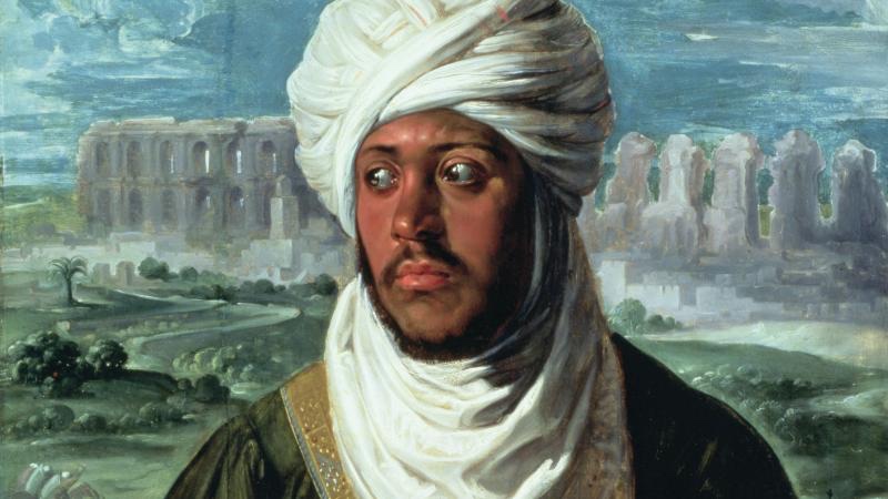 Portrait of a man wearing a white turban and draped white clothing, looking toward the side. His eyes are visible, and a landscape with ancient ruins appears in the background.